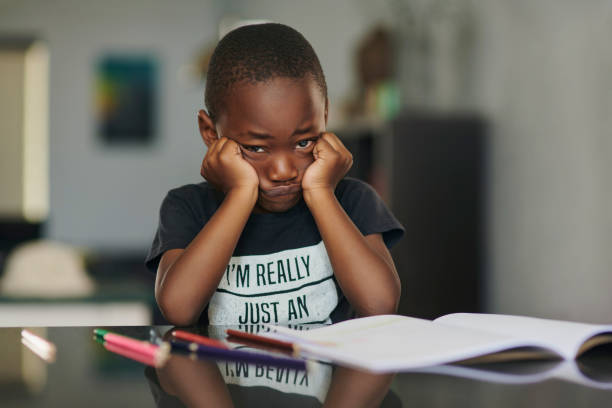 portrait d’enfant, de stress ou d’anxiété avec des livres dyslexie, crise d’éducation ou trouble d’apprentissage à la maison. enfant noir ennuyé, triste ou bouleversé avec cahier d’apprentissage, autisme ou expression faciale boudeuse - dyslexia &autism photos et images de collection